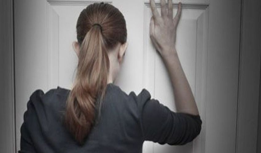 Vrouw wacht voor haar dichte voordeur in Huissen Vrouw wacht voor haar dichte voordeur in Huissen